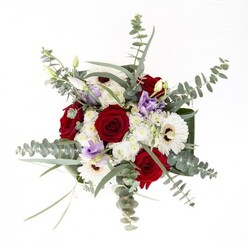 Crafted with thoughtful precision, this bouquet stands as an emblem of balance and intention for Temple's neighbourhood-ideally positioned in a sunlit alcove or historic office off Essex Street. The arrangement's deep red roses, plush and spiraled, serve as steadfast symbols of affection and accomplishment, while broad-petaled white gerberas reflect tranquil sophistication. Each flower's subtle texture invites the fingertips, their forms enhanced by delicate lavender lisianthus, whose tender petals and tightly closed buds offer the poetry of possibilities yet to unfold. Fluffy clusters of tiny white blooms fill the spaces between, echoing the gentle haze of early mist above the River Thames. Eucalyptus, its discs cool and silvery, adds both aromatic layers and a touch of contemporary greenery, framing the bouquet with an urban wildness. Robust, dark green leaves curve protectively around the base, tucking the flowers into a visual embrace above the glass vase, where the green stems shimmer below in clear fresh water. The atmosphere is at once uplifting and grounded, suited for commemorating personal milestones, offering sympathy, or simply inviting the freshness of spring into a Middle Temple residence. This display exemplifies the subtle artistry practiced daily by Temple's local florists, where every detail resonates with care and refined British charm.
